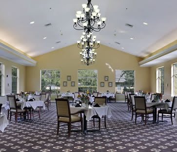 Elegant dining room with chandeliers and neatly arranged tables.