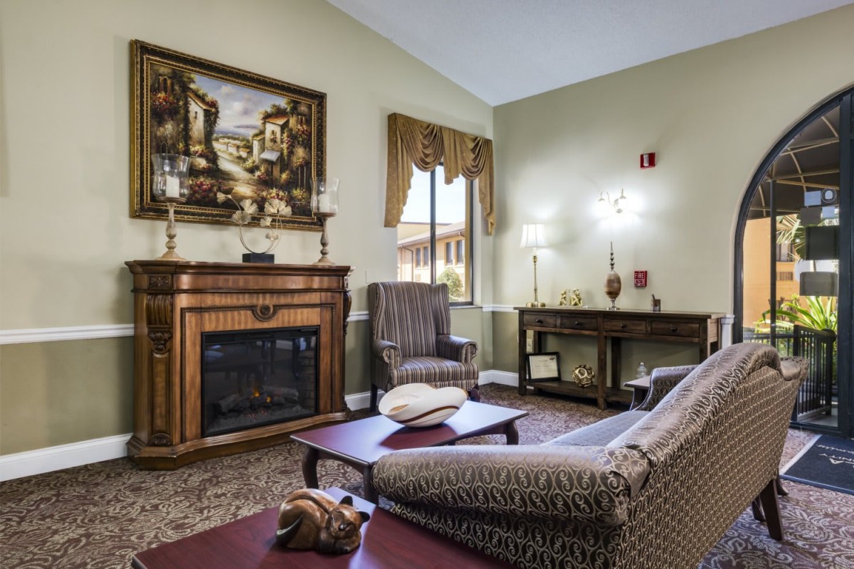 A cozy living room featuring a fireplace, elegant furniture, and artwork on the wall.