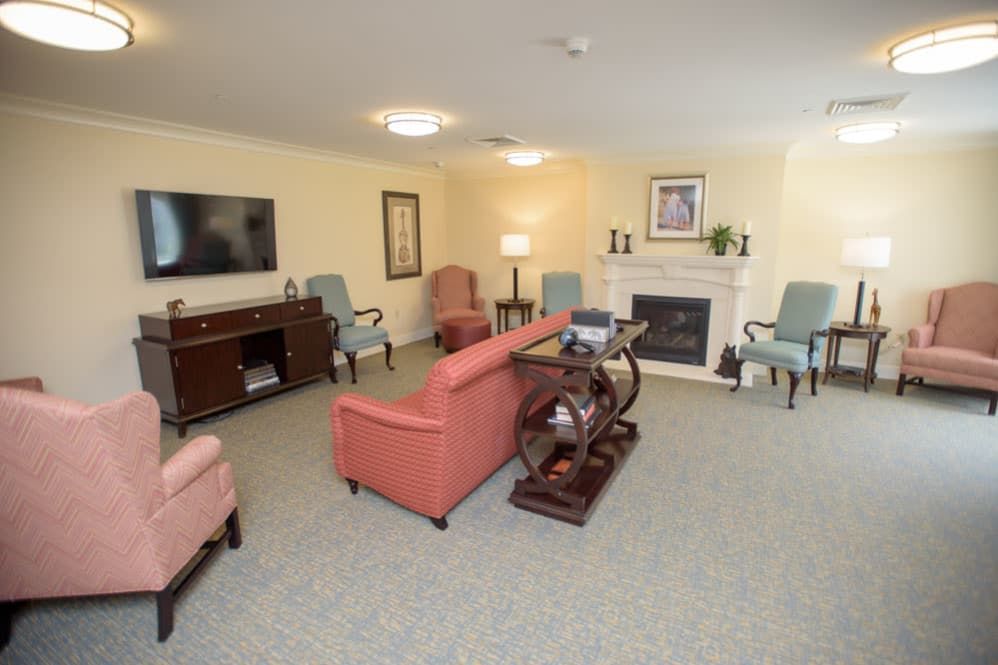 A cozy living room with a fireplace, comfortable seating, and a television.