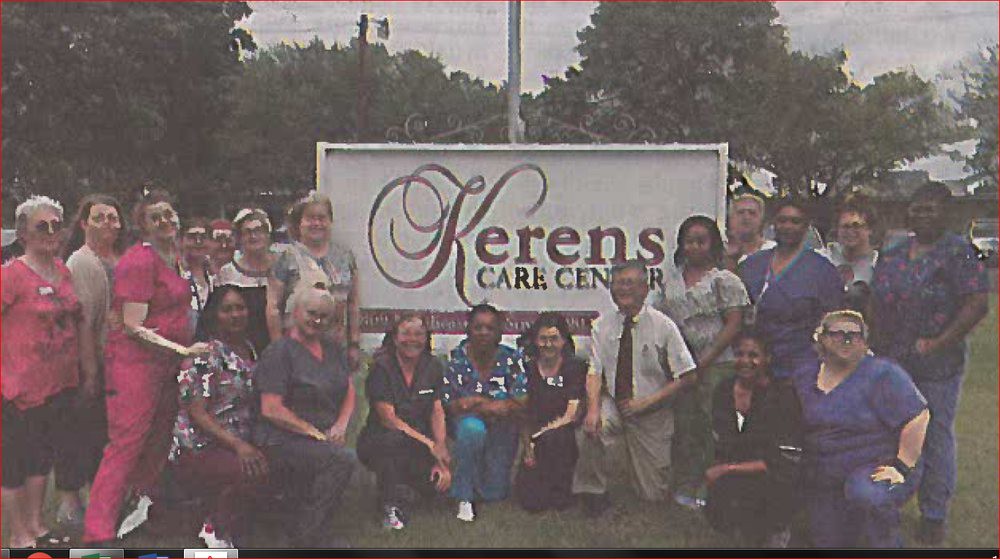 A group photo of healthcare workers in front of the Kerens Care Center sign.