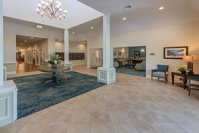 Spacious lobby with elegant chandelier and seating area.