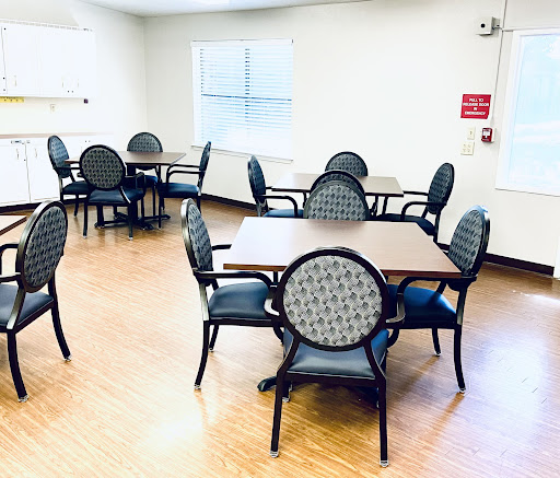 A spacious dining area featuring multiple tables and chairs, designed for casual gatherings.