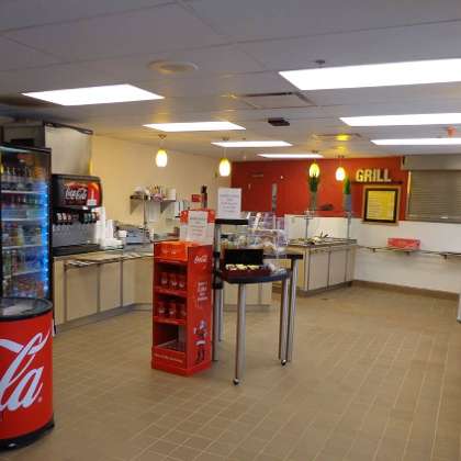 A spacious and modern interior of a restaurant featuring a beverage cooler and snack preparation area.