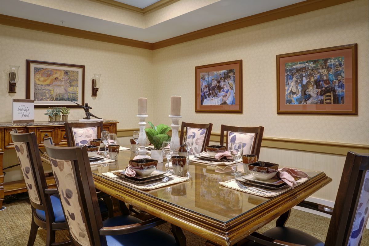 A well-appointed dining room with an elegant table setting and framed artwork on the walls.