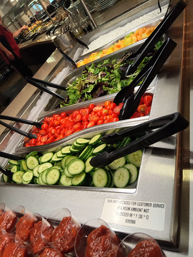 A colorful display of fresh vegetables at a salad bar.