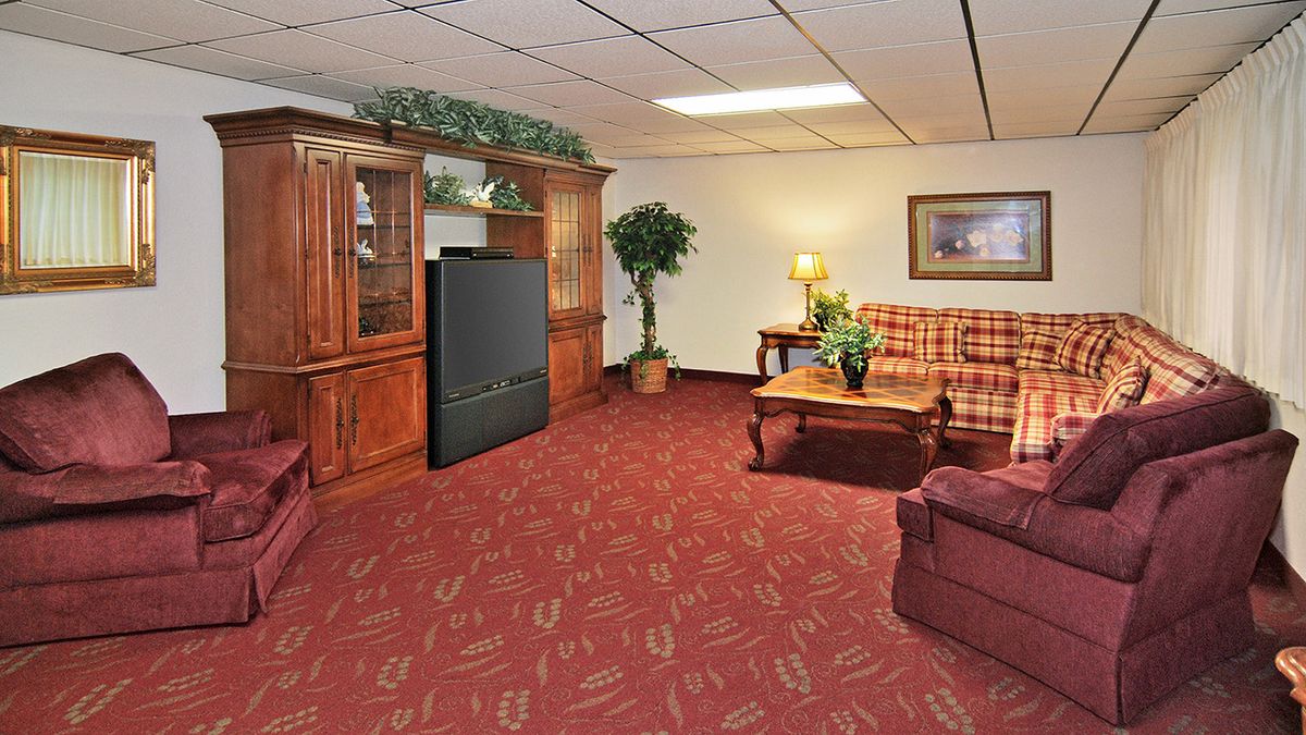 A cozy living room with a plaid sofa, wooden furniture, and a television.