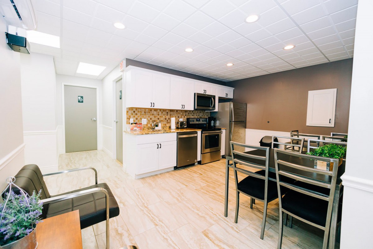 A modern kitchen with stainless steel appliances and a dining area.