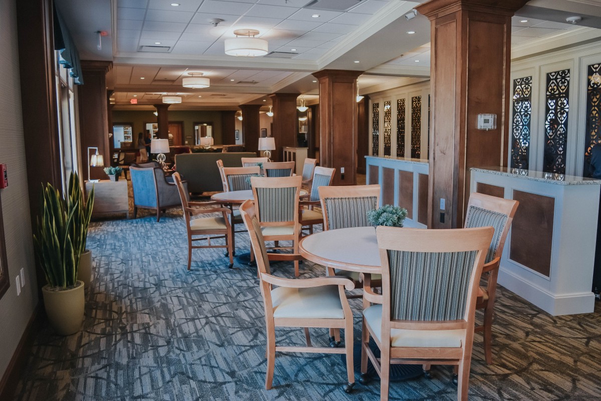 A spacious dining area with wooden furniture and elegant lighting.