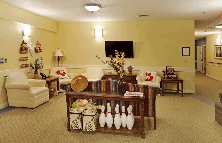 A cozy living room featuring comfortable seating, decorative items, and a television.