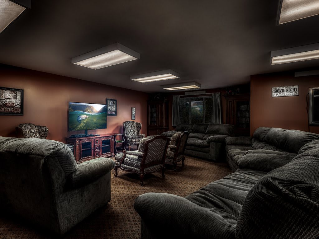 A cozy home theater room with comfortable seating and a large television.