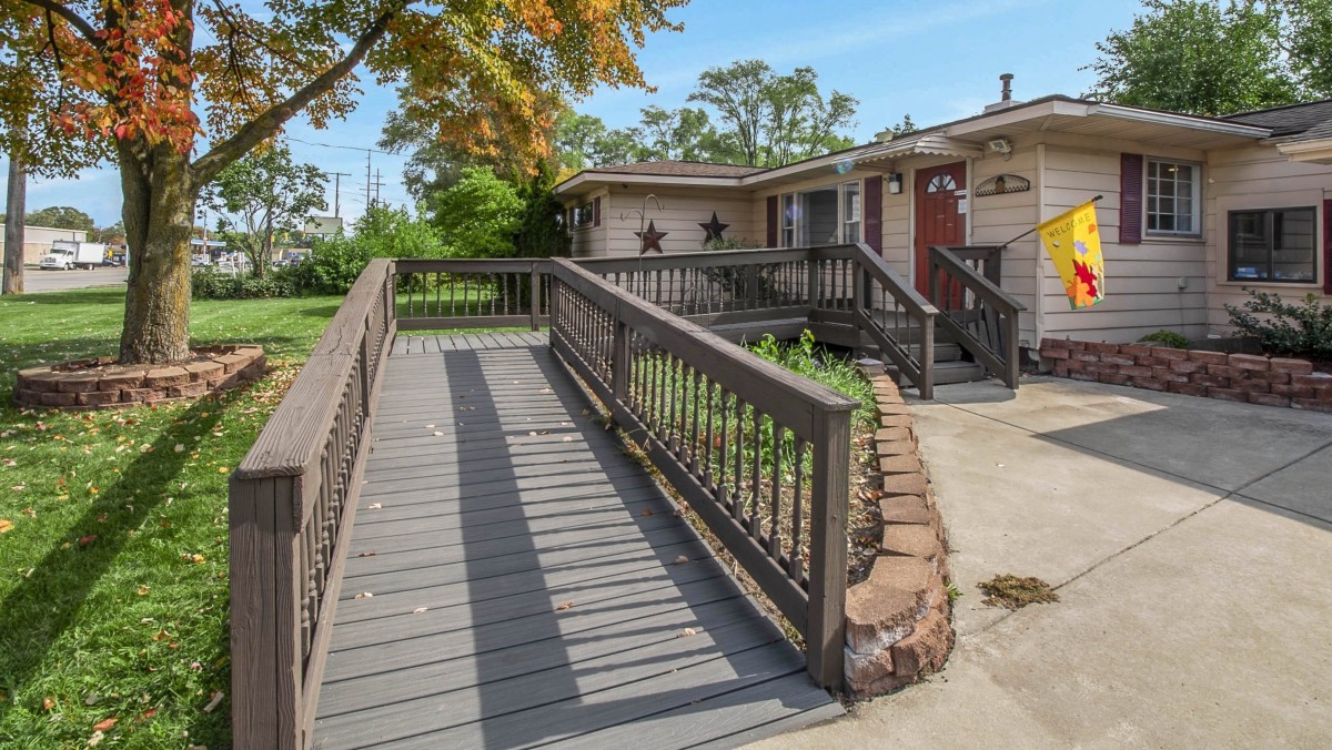 A suburban house with a wooden ramp leading to the entrance.