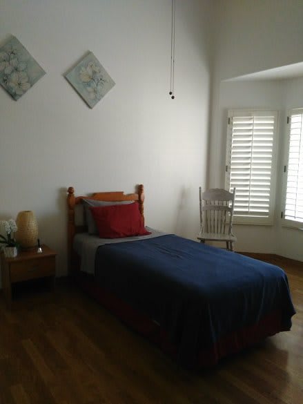 A minimalist bedroom with a single bed and natural lighting.