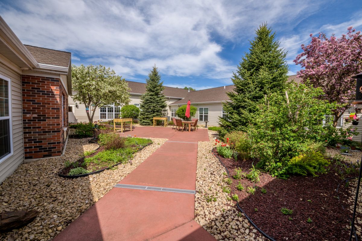 A well-maintained courtyard with a paved pathway surrounded by trees and landscaping.