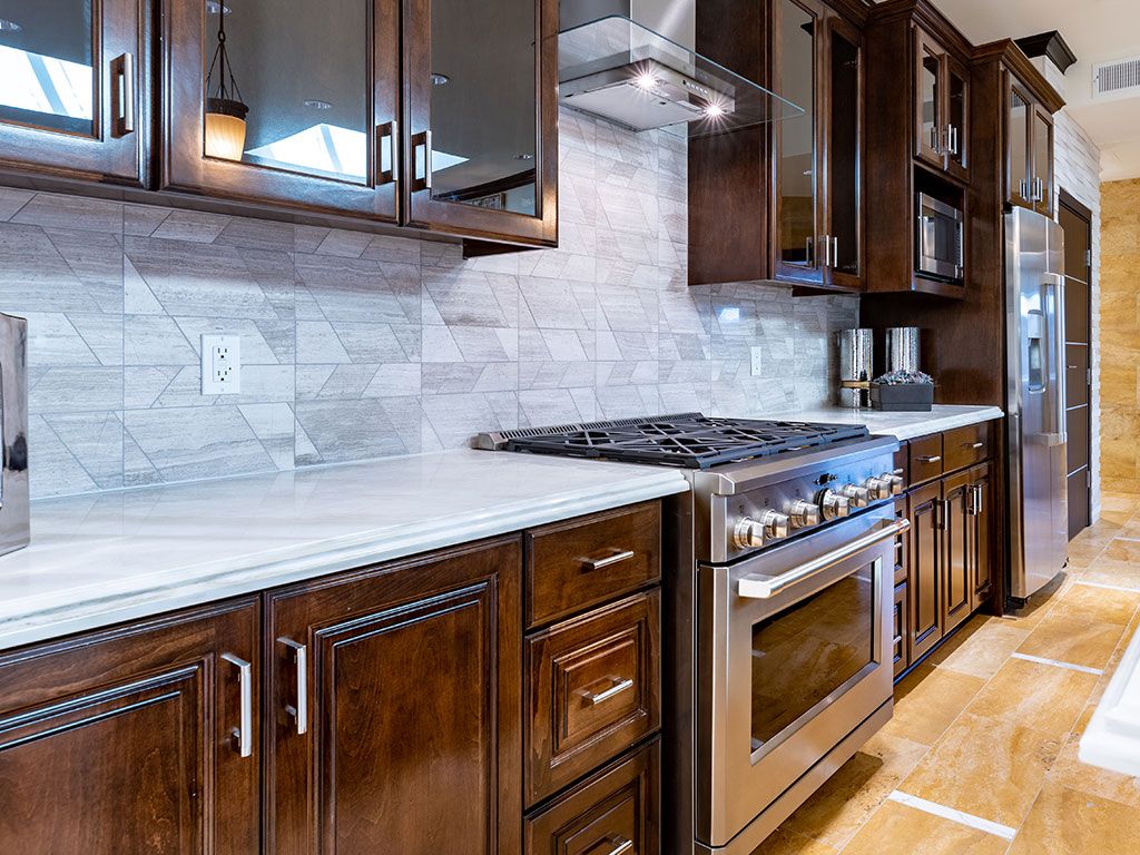A modern kitchen with dark wooden cabinets and a stainless steel stove.