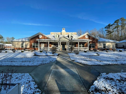 A beautiful winter scene featuring a cozy house adorned with snow under a bright blue sky.