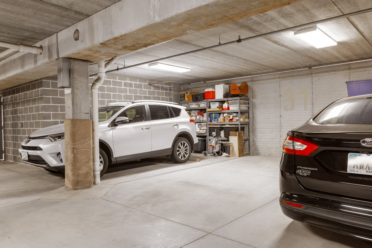 A view of a garage with parked cars and organized storage shelves.