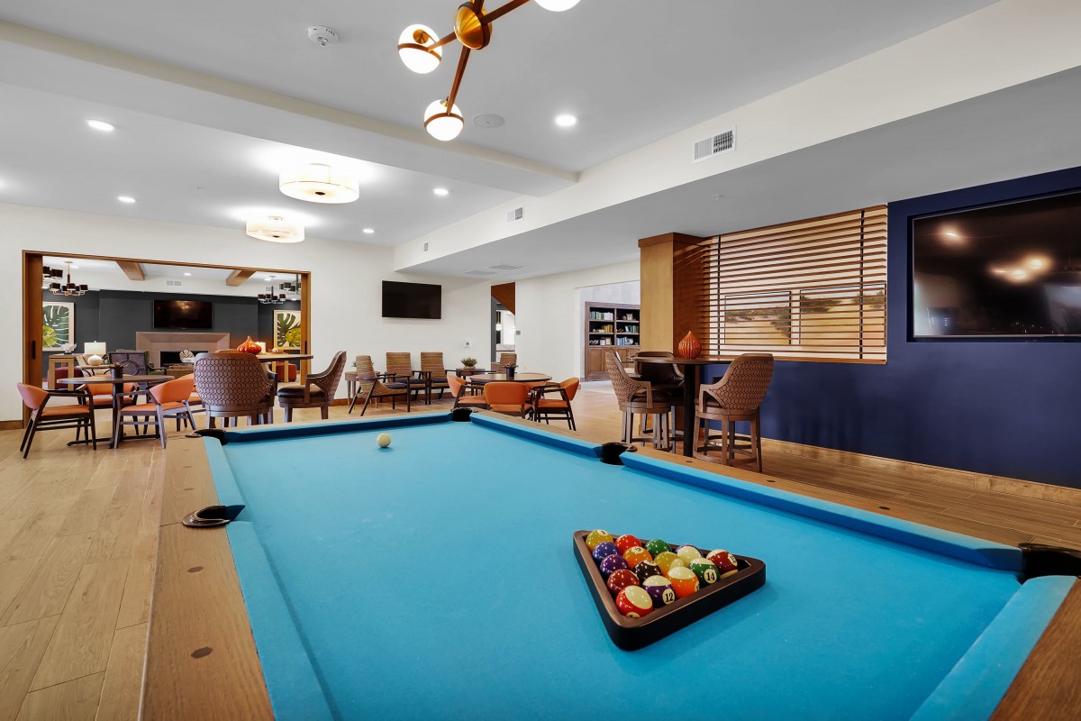 A modern game room featuring a pool table and comfortable seating.