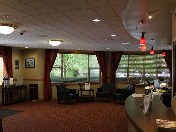 A cozy lobby with a seating area and large windows.