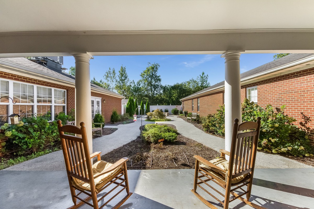 Two rocking chairs overlook a beautifully landscaped courtyard.