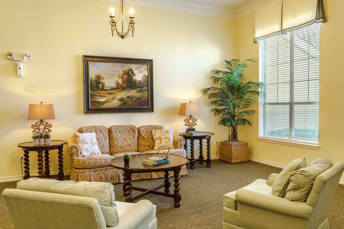 A cozy living room with a sofa, coffee table, and a painting on the wall.