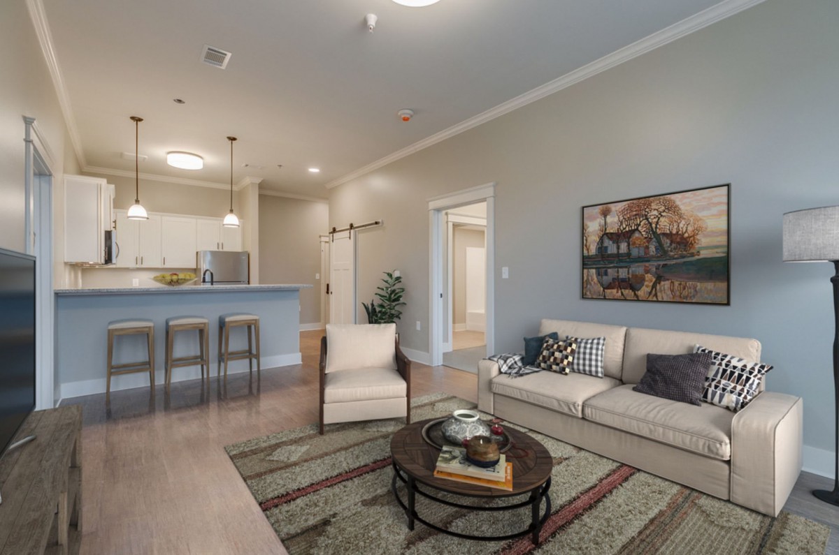 A modern open-concept living room with a cozy seating area and kitchen bar.