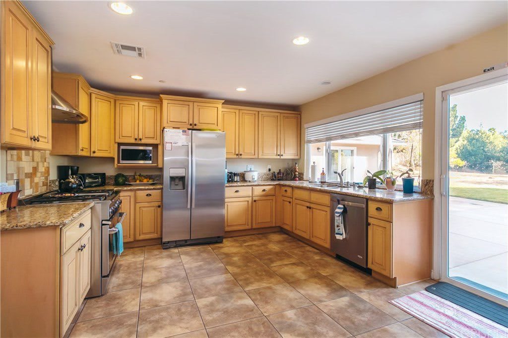 A modern, spacious kitchen with wooden cabinets and stainless steel appliances.