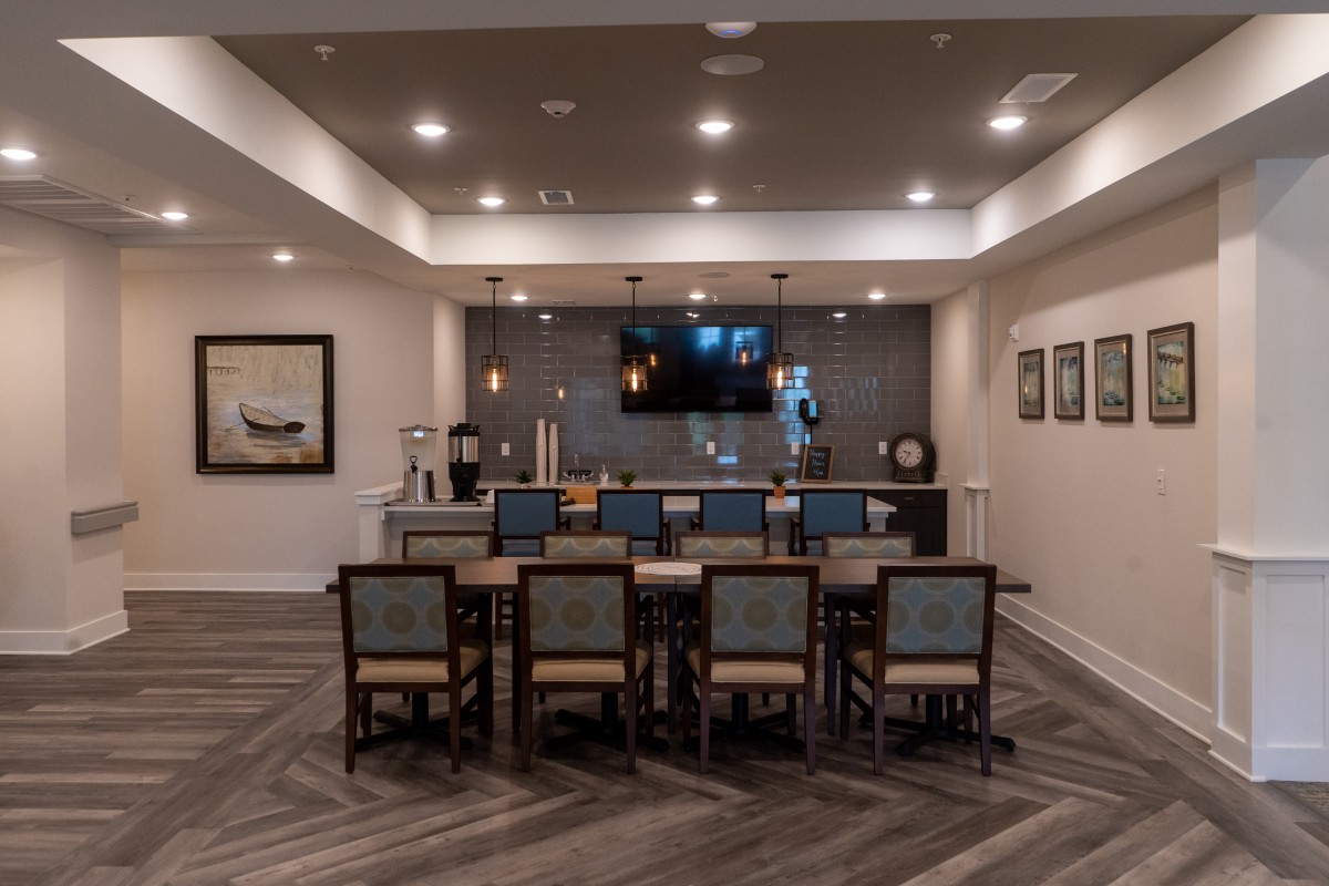 Modern conference room with a long table, chairs, and a TV on the wall.