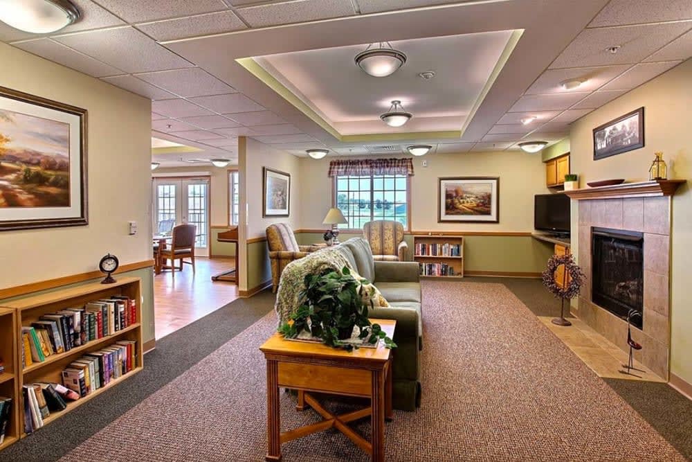A cozy living room area featuring a comfortable sofa, vibrant decor, and ample natural lighting.