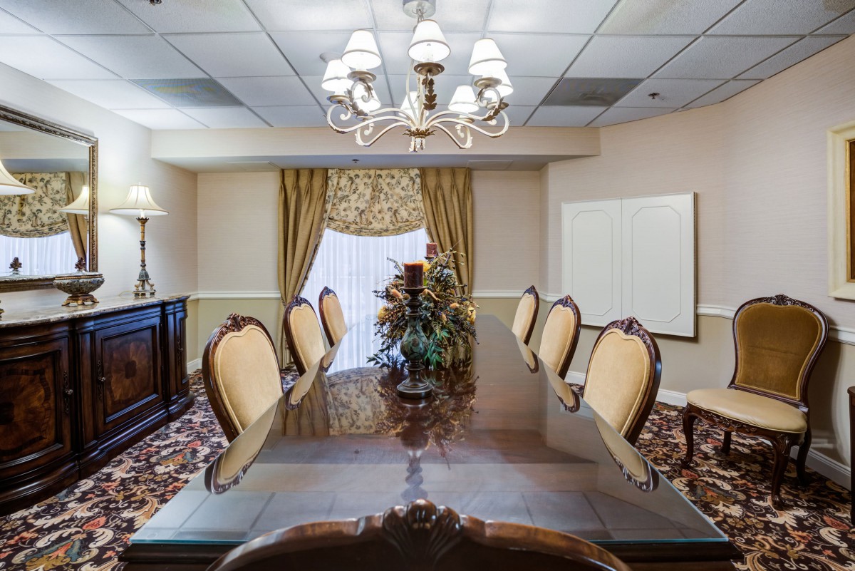 An elegantly decorated conference room with a long meeting table and chandelier.