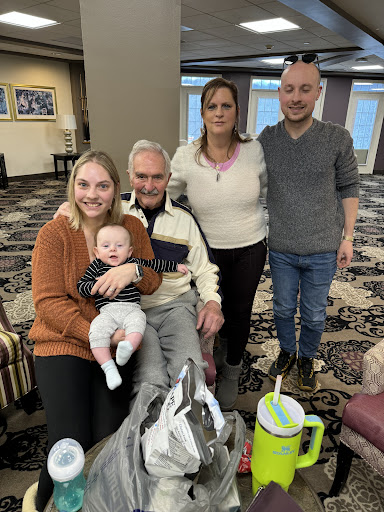 A joyful family gathering with smiles and a little one in the center.