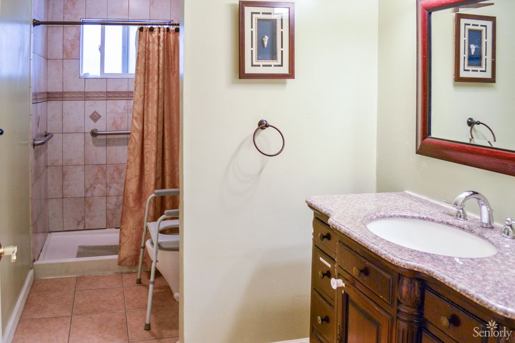 A cozy bathroom with a shower area, sink, and wooden vanity.