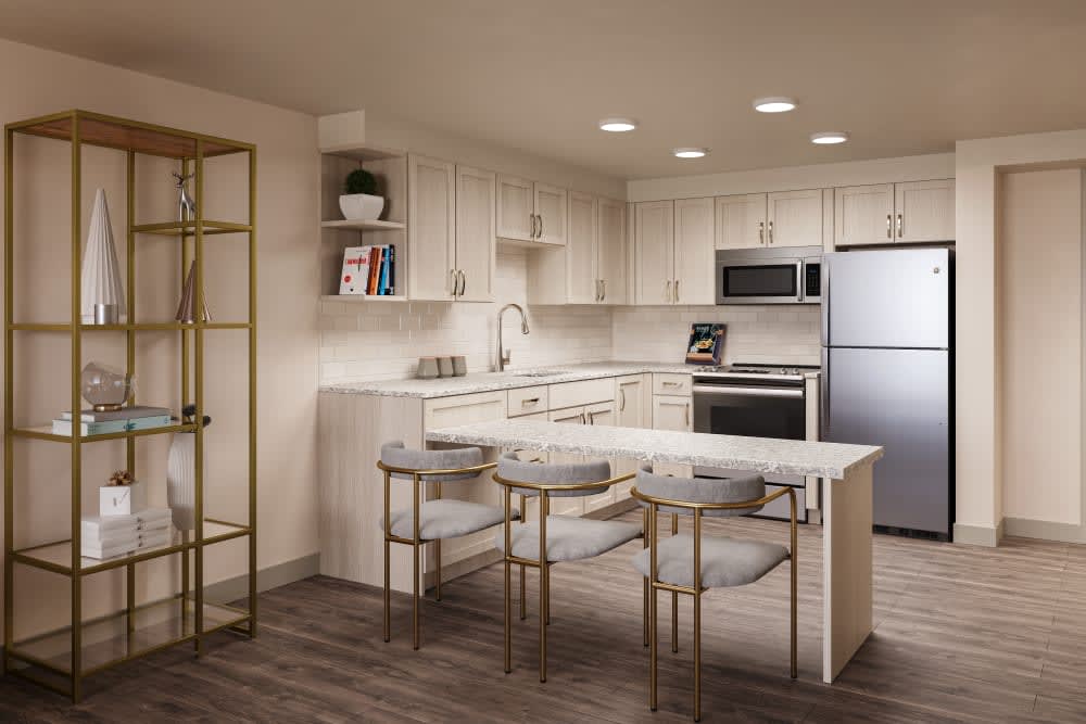 A modern kitchen with sleek appliances, bar stools, and cozy lighting.