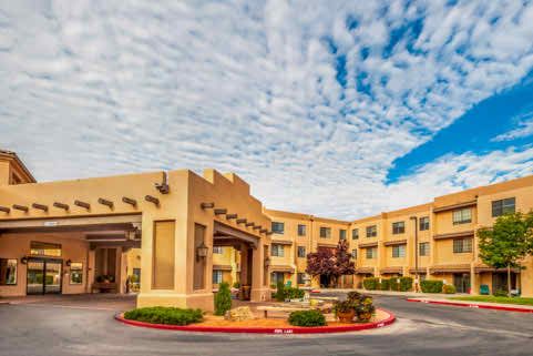 A picturesque hotel building with unique architectural design set against a vibrant sky backdrop.