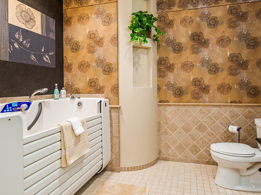 A cozy bathroom featuring vintage wallpaper, a walk-in bathtub, and a small potted plant.