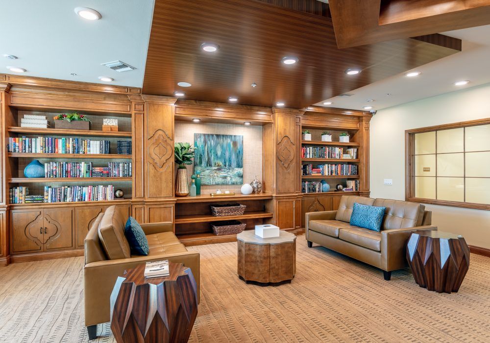 A modern library interior with wooden bookshelves and comfortable seating.