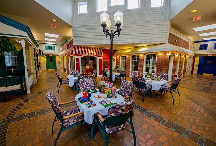 A cozy indoor dining area with tables and chairs, featuring decorative elements and a central lamppost.