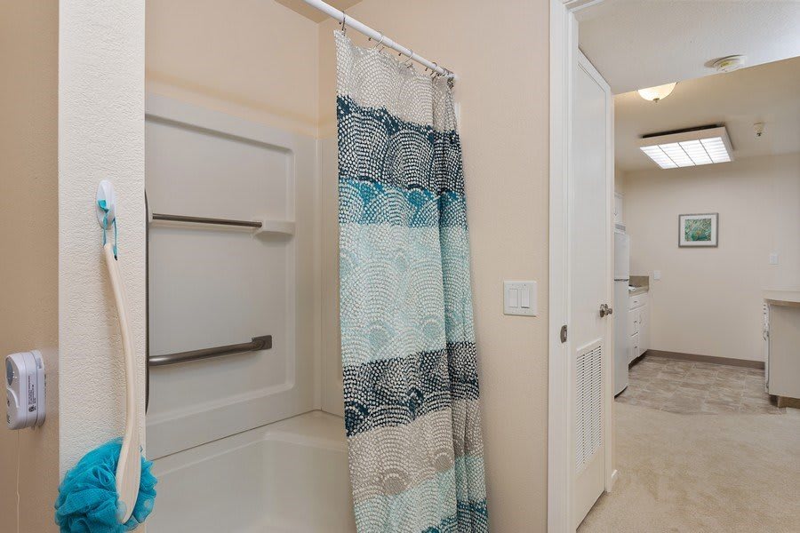 A bathroom featuring a patterned shower curtain and a built-in bathtub with towel racks.