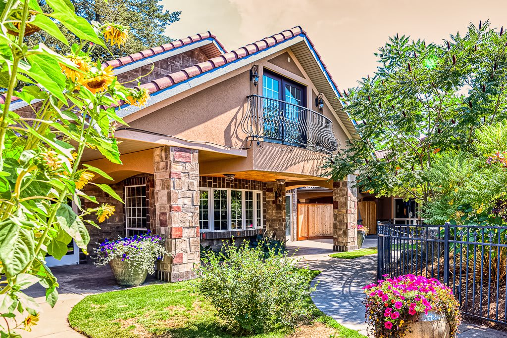 A beautiful house surrounded by a lush garden and vibrant flowers.