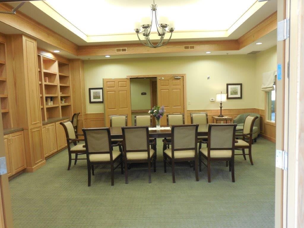 A modern meeting room with a large conference table and chairs.