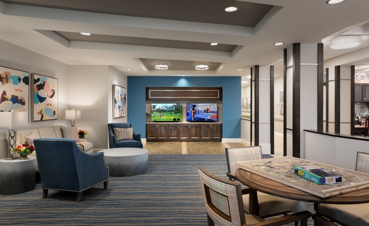 A modern living room with comfortable seating and dual televisions on a blue accent wall.