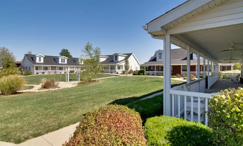 A serene suburban neighborhood with well-maintained lawns and houses.