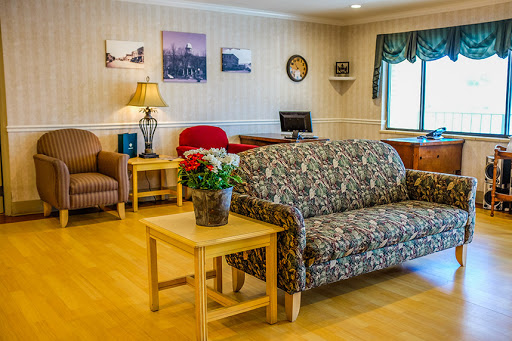 A cozy living room setting featuring a patterned sofa, wooden furniture, and decorative elements.
