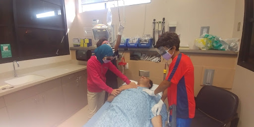 Students participating in a medical simulation activity in a hospital setting.