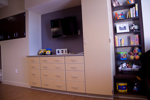 A stylish interior featuring a TV mounted on the wall and a sleek storage unit with multiple drawers.
