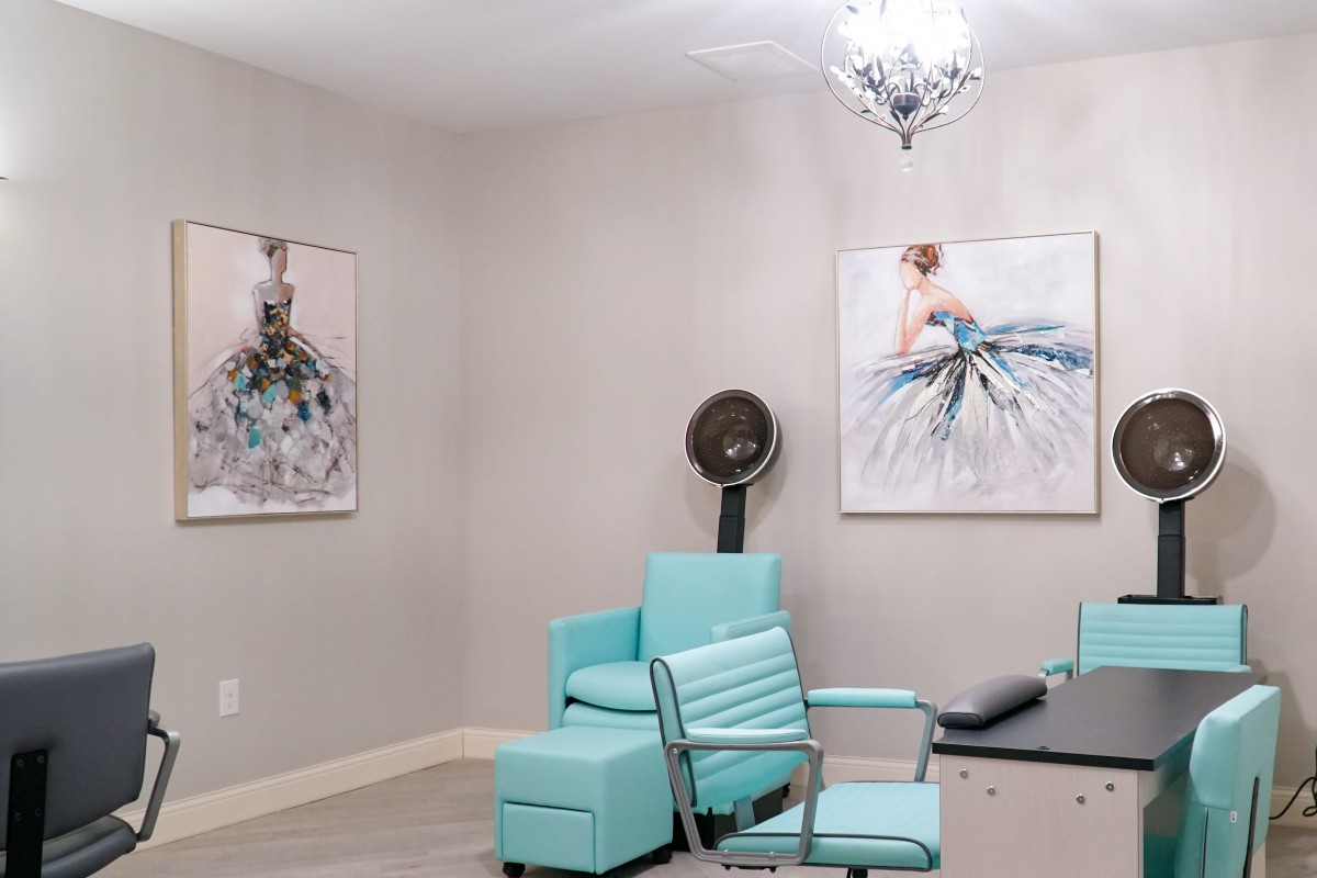 A modern salon interior with turquoise furniture and decorative artwork on the walls.