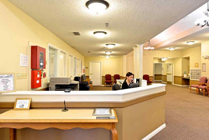 A reception area with a desk, computers, and seating.