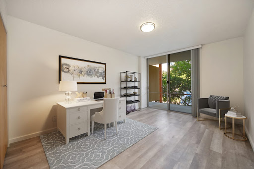 A bright and modern home office featuring a stylish desk, ergonomic chair, and ample natural light.