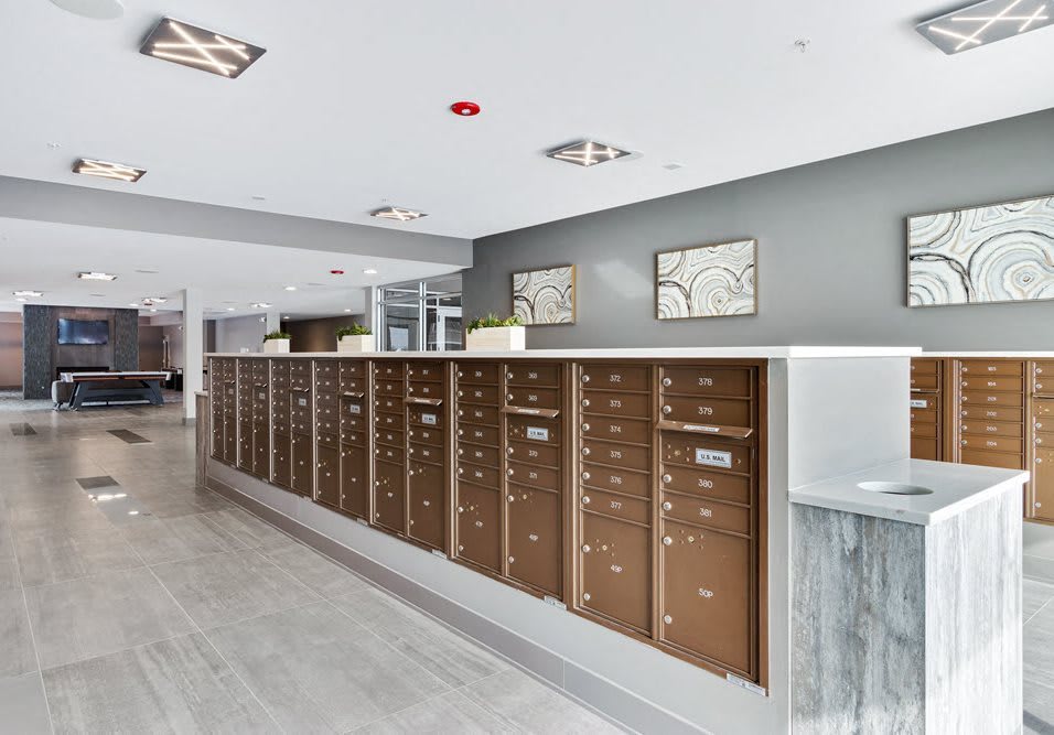 A modern apartment lobby with a row of mailboxes.