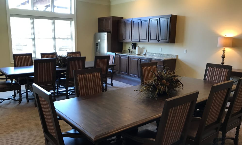 A spacious dining area with a table and chairs adjacent to a kitchen setup.