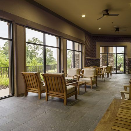 A spacious indoor seating area with wooden furniture and large windows allowing natural light.